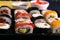 Different kinds of rolls stand on a black plate that stands on a black background