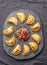 Different little cocktail EMPANADAS on stone plate with tomato sauce and guacamole . Gray background. Latin American and Spanish