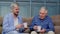 Different male generations family of senior father and adult son or grandson relaxing, drinking tea