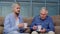 Different male generations family of senior father and adult son or grandson relaxing, drinking tea