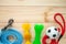 Different multicolored pet care accessories: ring, bones, balls on natural wooden background. Rubber and textile accessories