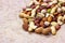 Different nuts: almonds, pistachios, peanuts, hazelnuts mix heap on light background.