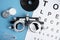 Different ophthalmologist tools on light blue background, flat lay