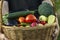 Different Organic Fruits and vegetables in basket on grass background.