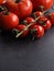Different organic tomato varieties on a dark stone kitchen table