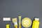 Different paintbrushes with paint rollers and cans of yellow paint on dark background