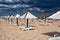 Different parasols and sun loungers on the empty beach on Tavira island before storm, Algarve. Portugal