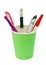 Different pens in a green plastic cup