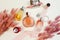 Different perfume bottles, earrings, pink silk ribbon and herbs Lagurus. Beauty flatlay, top view