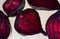 Different pieces of fresh, raw, red beet in section in unusual composition on white background.