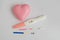 Different positive pregnancy tests with a pink heart