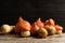 Different pumpkins on table against wooden wall.