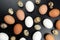 Different quail and chicken eggs lie on dark background