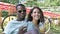 Different races couple drinks lemonade laughing in park