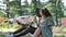 Different races couple sits on park grass eating ice-cream