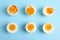 Different readiness stages of boiled chicken eggs on blue background, flat lay