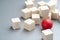 Different red ball in the group of wooden cubes