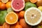 Different ripe citrus fruits as background, top view