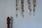 Different rosaries hanging on blue wall by bed and copy space