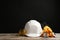 Different safety equipment on wooden table against black background.