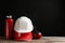 Different safety equipment on wooden table against black background.