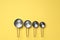 Different saucepans on yellow background, flat lay with space for text. Cooking utensils