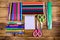 Different school stationeries pens, notepad, pencils, felt tip pens, scissors and ruler on a wooden background. Top view