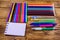 Different school stationeries pens, notepad, pencils and felt tip pens on a wooden background