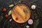 Different seasoning for cooking on a dark background. Empty wooden plate, spices, herbs, vegetables. Top view, flat lay