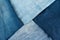 Different shades of blue denim fabric. Detail of several layers of jeans