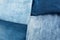 Different shades of blue denim fabric. Detail of several layers of jeans