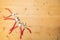 Different sizes of red pliers on a wooden background. Top view of repairing work tools on a wooden table