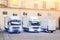 Different small and medium courier service  trucks and van at building courtyard. City delivery cargo shipping company vehilcles