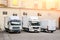 Different small and medium courier service  trucks and van at building courtyard. City delivery cargo shipping company vehilcles