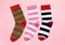 Different striped socks on light pink background, flat lay