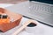 Different sushi rolls with salmon in delivery paper box on white marble table background with laptop - futomaki, uramaki