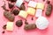 Different sweets on pink background: marshmallows, zephyr and chololate.