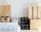 Different takeout containers, packages and carton cups on table against white wall.