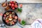 Different tiny pancake cereal in a pan with honey and strawberries on a wooden background. Top view. Copy space