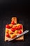 Different tomato cultivars on a wood board on the black background. top view