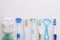 Different tongue cleaners, dental flosses and toothbrushes on white background, top view