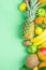 Different Tropical Summer Fruits. Pineapple Mango Coconut Citrus Oranges Lemons Apples Kiwi Bananas on Turquoise Background