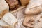 Different types of bread from the bakery, lie on a wooden oak board. Around walnuts and hazelnuts.