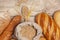 Different types of bread with wheat ears, grains, on a wooden table top view.