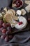 Different types of cheese with grape on wood board