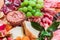 Different types of cheeses, wines, baguettes, fruits and snacks on the table for tasting and holiday scenery