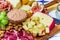 Different types of cheeses, wines, baguettes, fruits and snacks on the table for tasting and holiday scenery