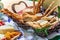 Different types of cheeses, wines, baguettes, fruits and snacks on the table for tasting and holiday scenery