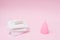 Different types of feminine hygiene products - menstrual cups, sanitary pads and tampon. pink background with copy space