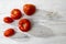 Different types of fresh tomatoes lie on beige wooden table